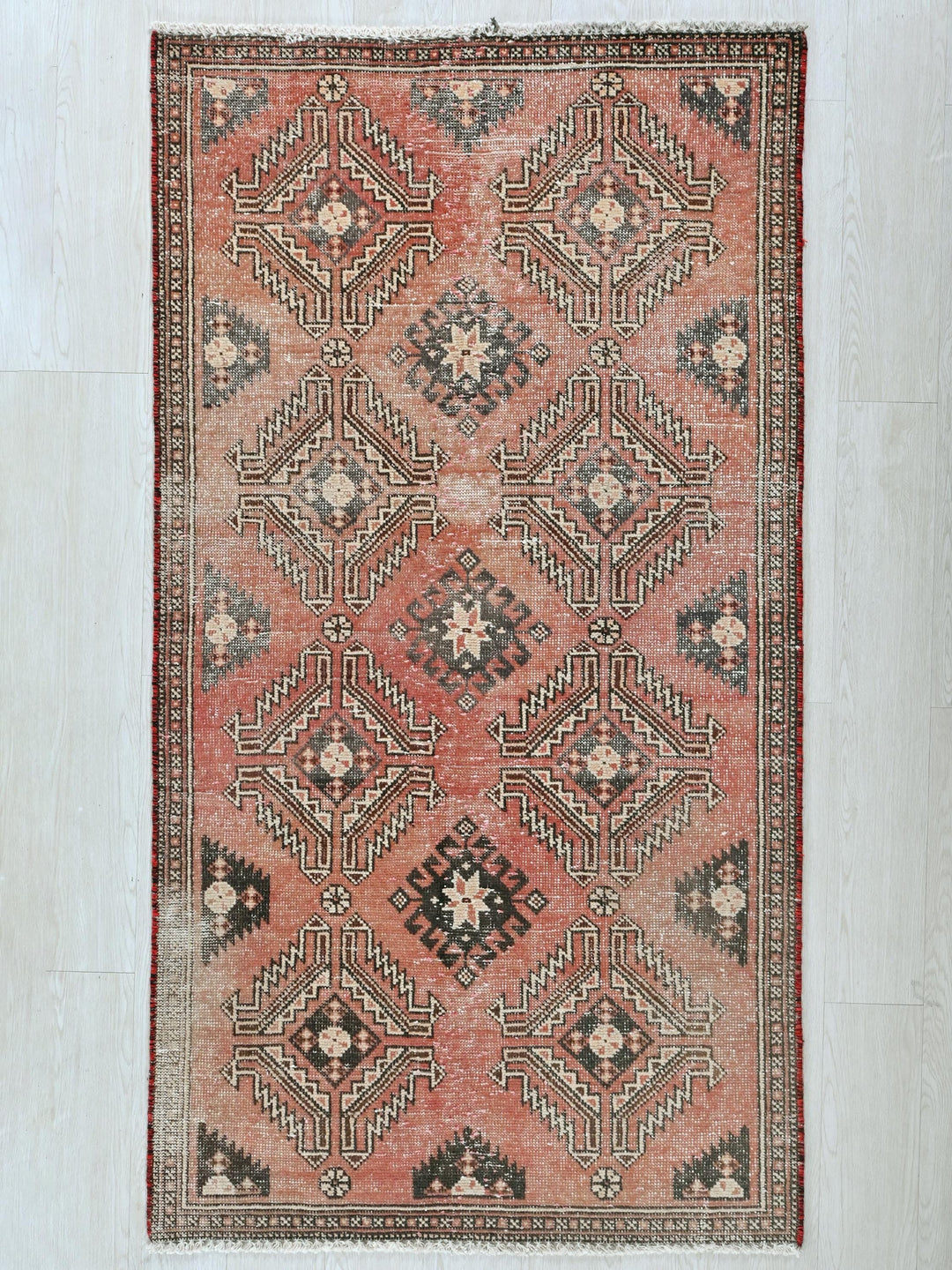 a red and black rug on a white floor