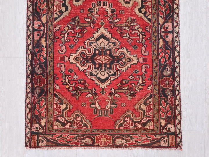 a red rug with an intricate design on it