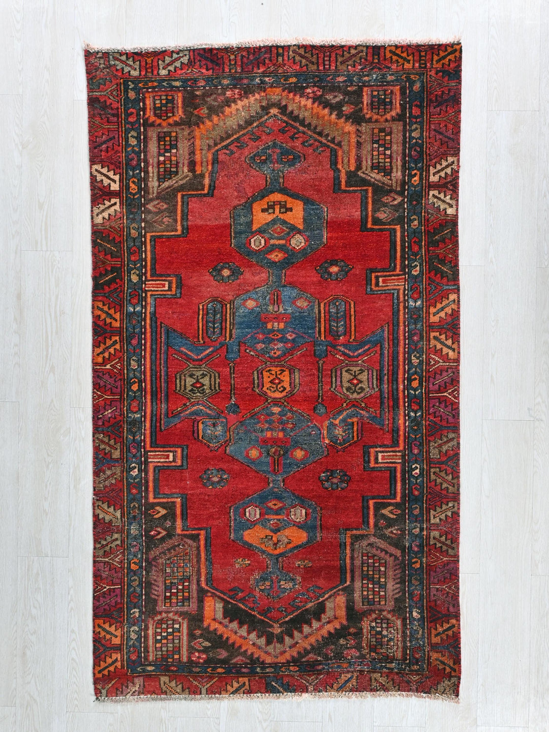 a red rug with a design on the middle of it