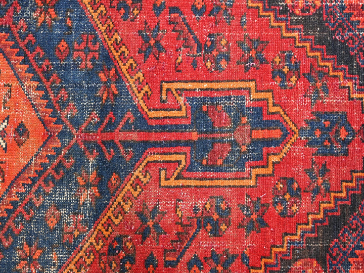 a red rug with blue and yellow designs on it