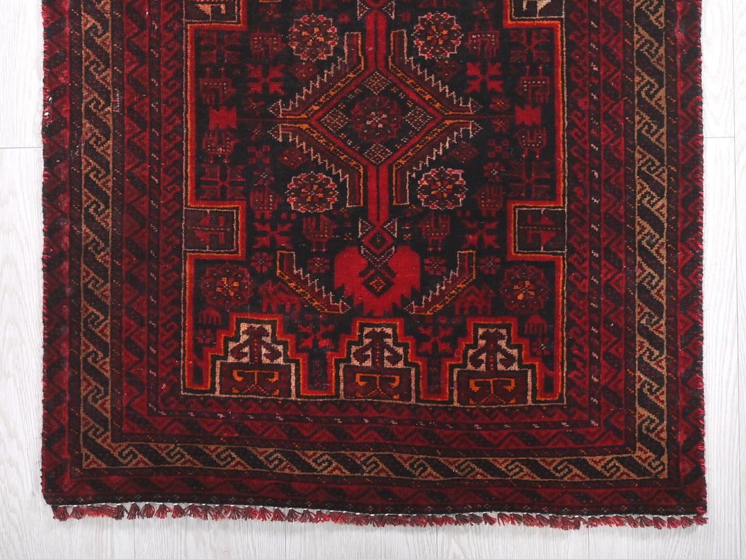 a red and black rug on a white floor