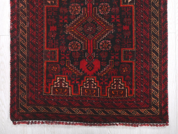 a red and black rug on a white floor