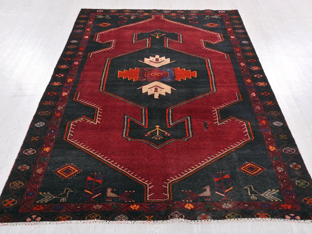 a red and black rug on a white floor