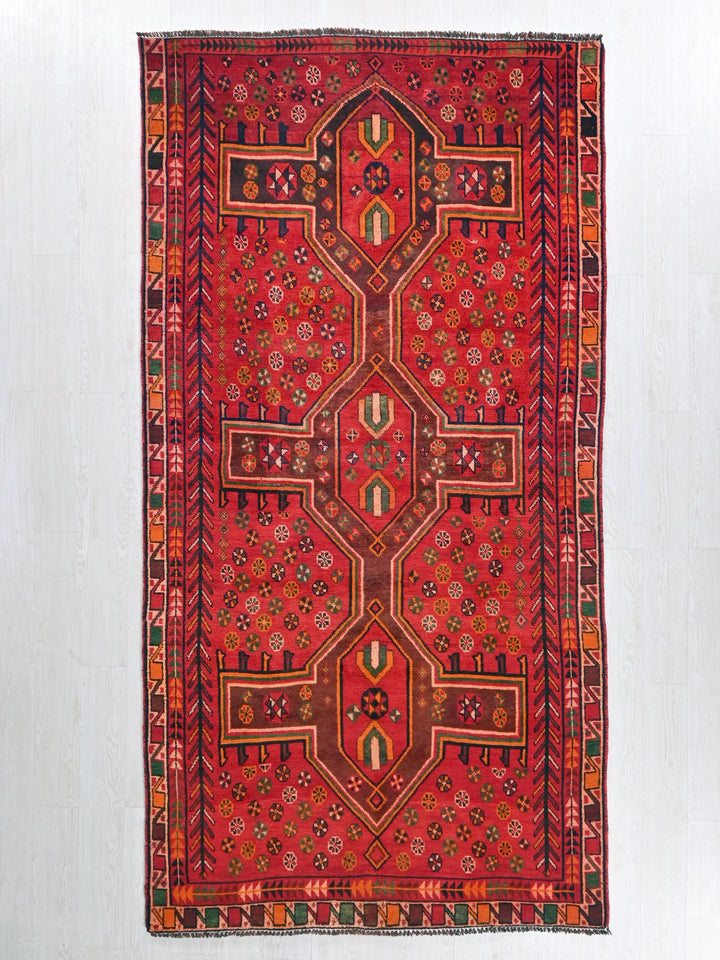 a red rug hanging on a wall