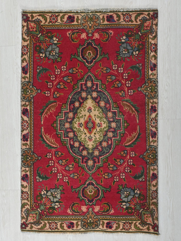a red rug with a floral design on it