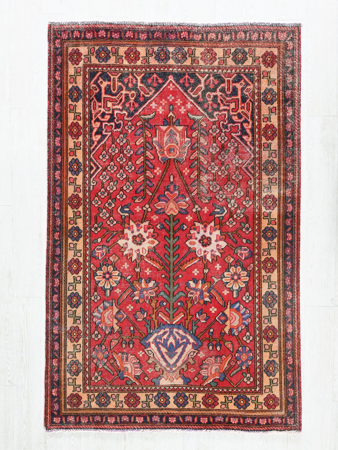 a red rug with a floral design on a white background