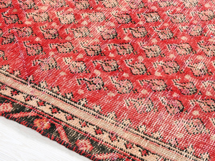 a close up of a red rug on a white floor