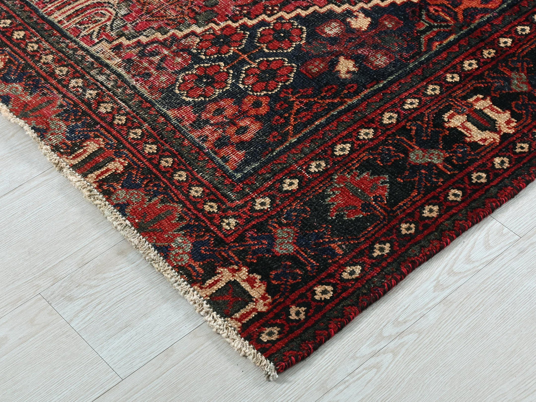 a red and black oriental rug on a white floor
