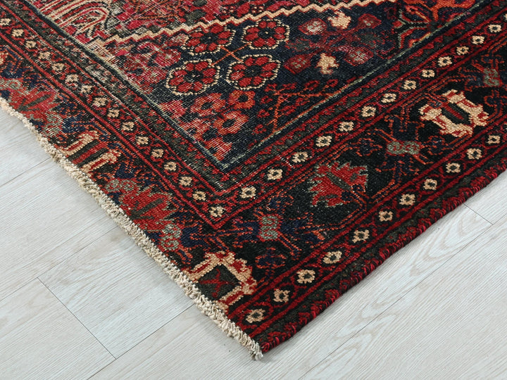 a red and black oriental rug on a white floor