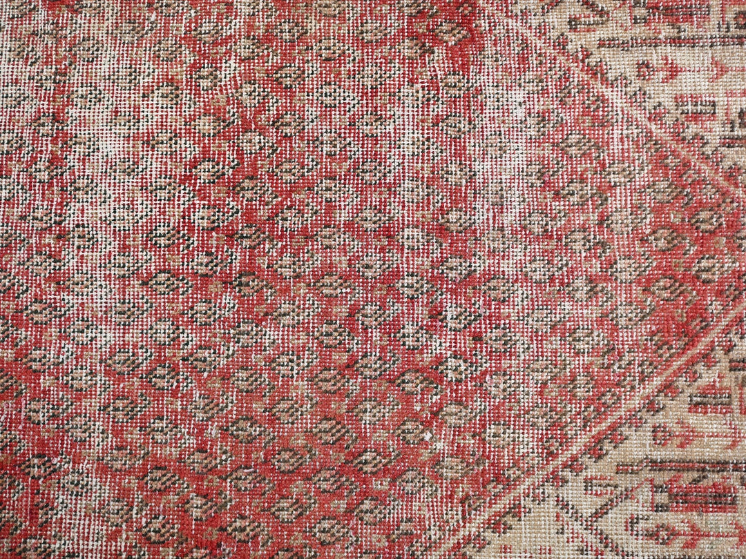 a close up of a red and beige rug