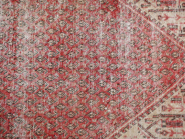 a close up of a red and beige rug