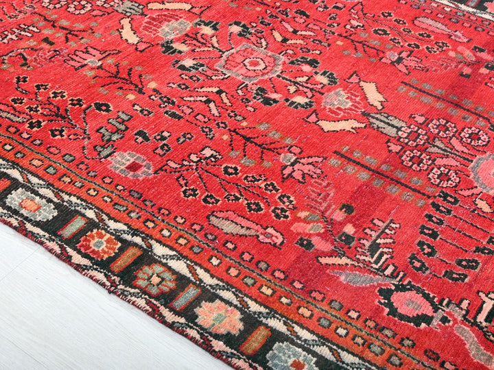 a red oriental rug on a white wooden floor