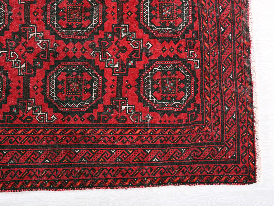 a red rug with black and white designs on it