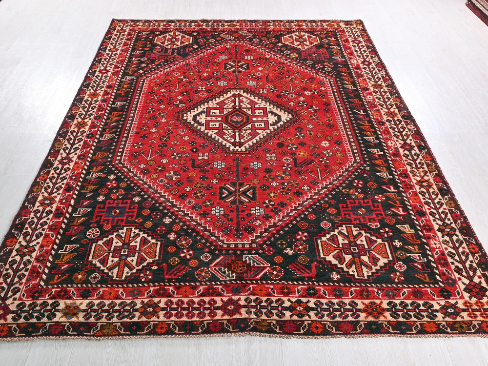 a red and black oriental rug on a white floor