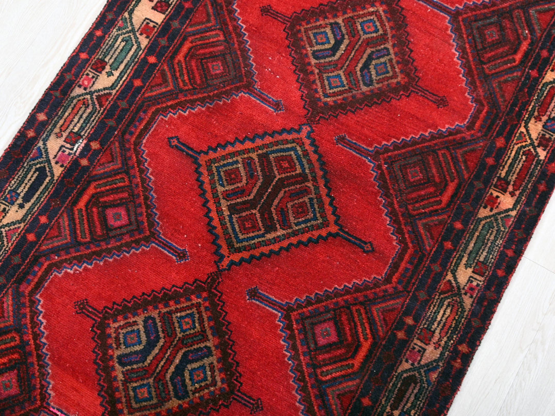 a red rug with a design on it