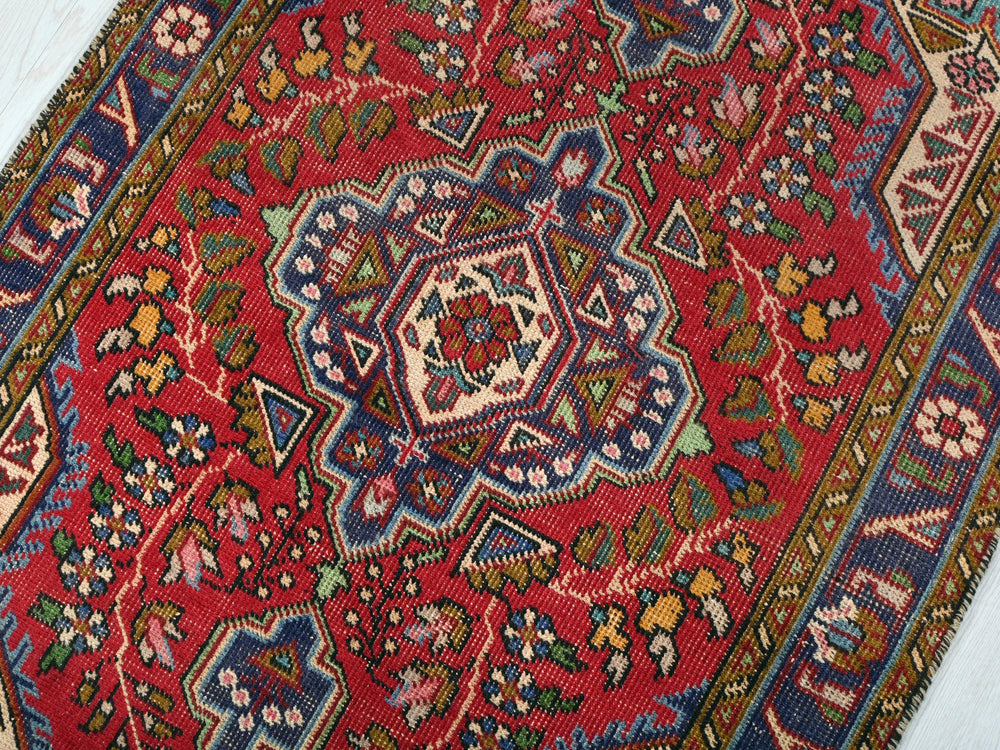 a red rug with a blue and green design on it