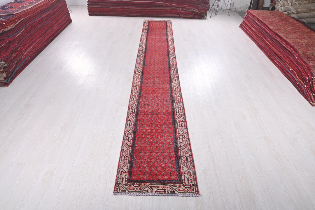a long red rug sitting on top of a white floor