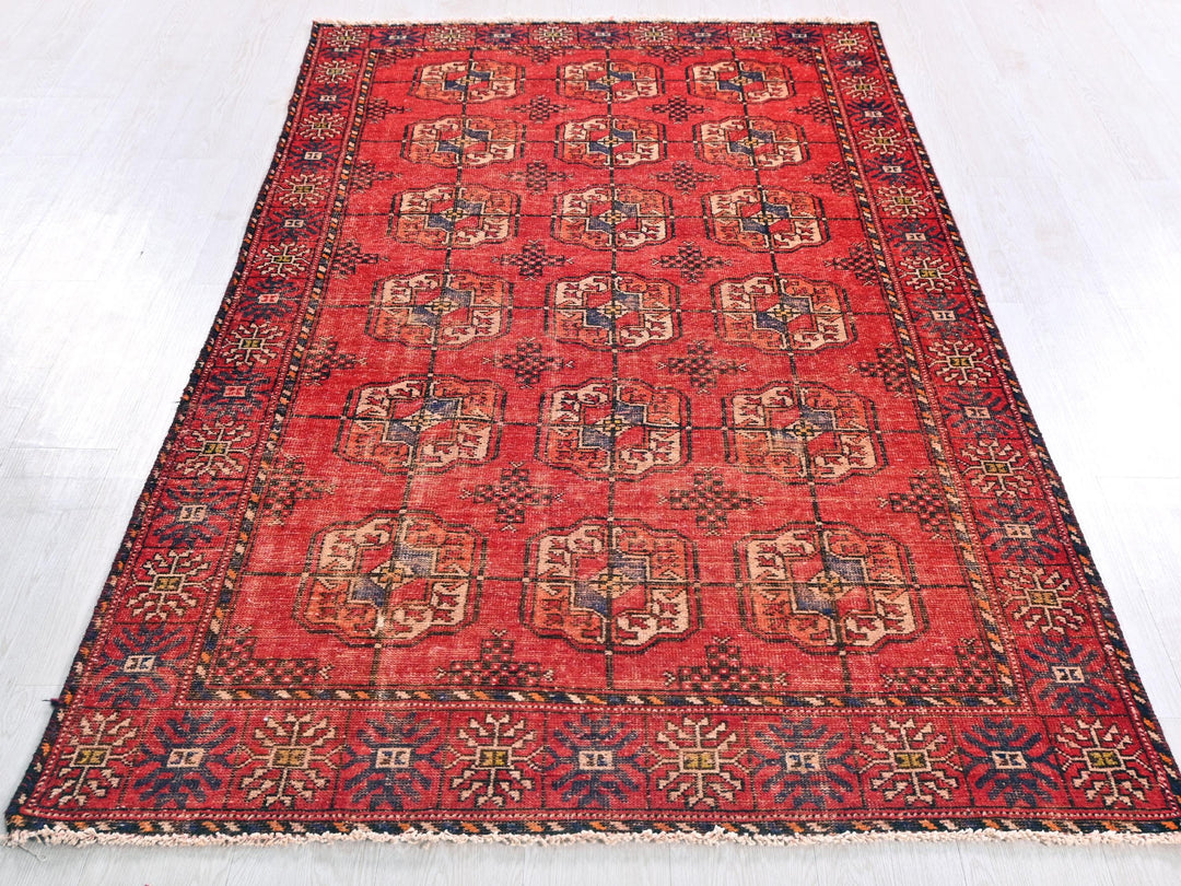 a red rug with a design on the middle of it