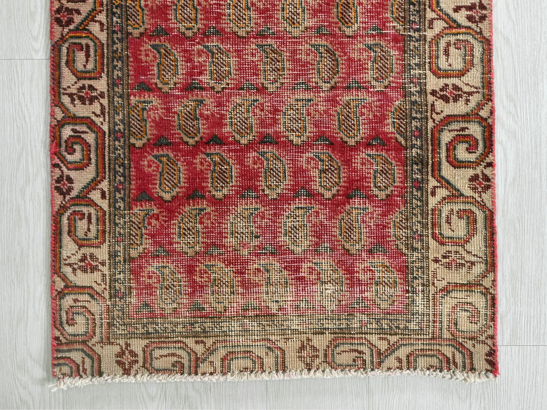 a red and beige rug on a white floor