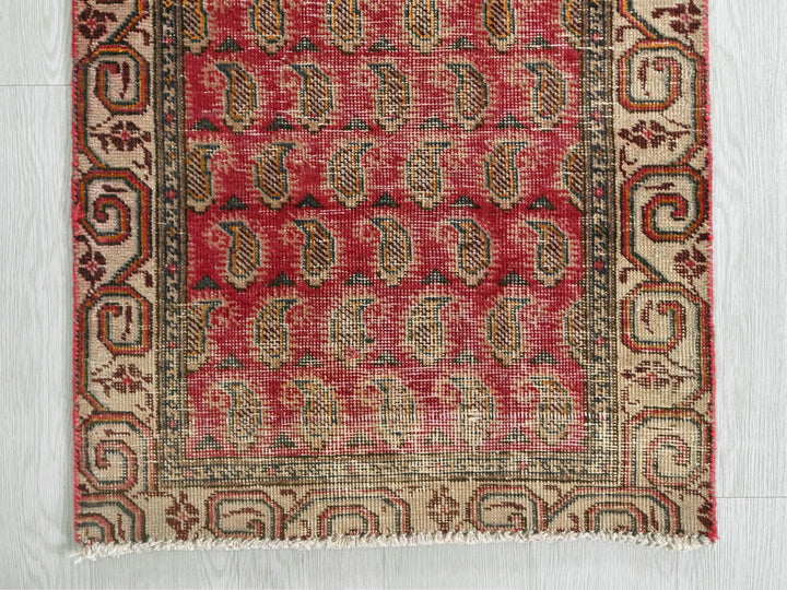 a red and beige rug on a white floor