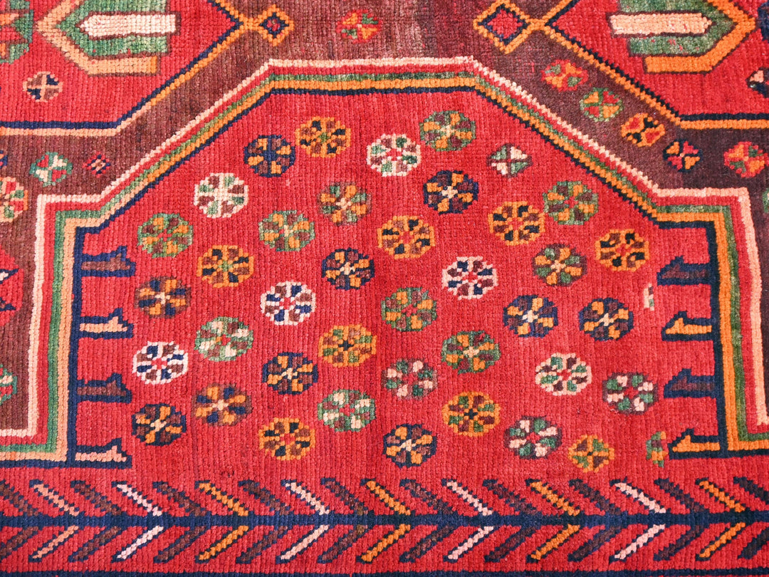 a red rug with a design on it