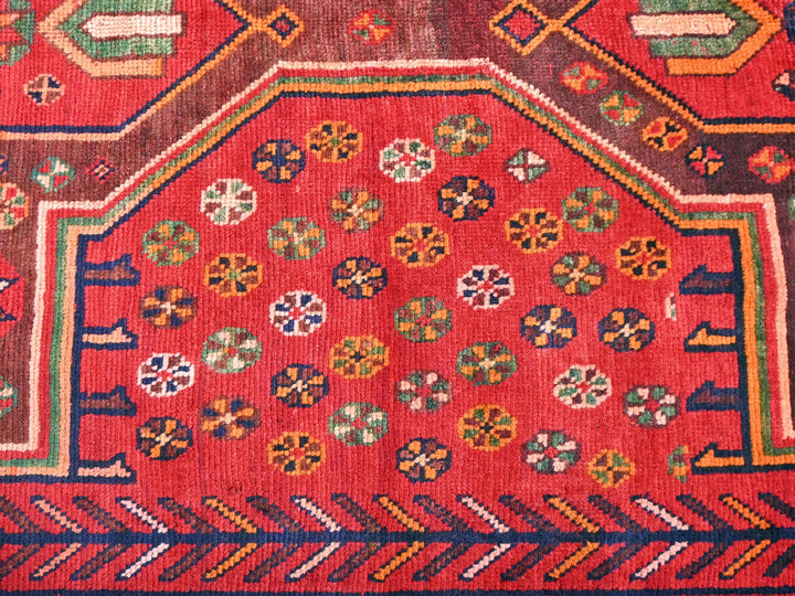 a red rug with a design on it