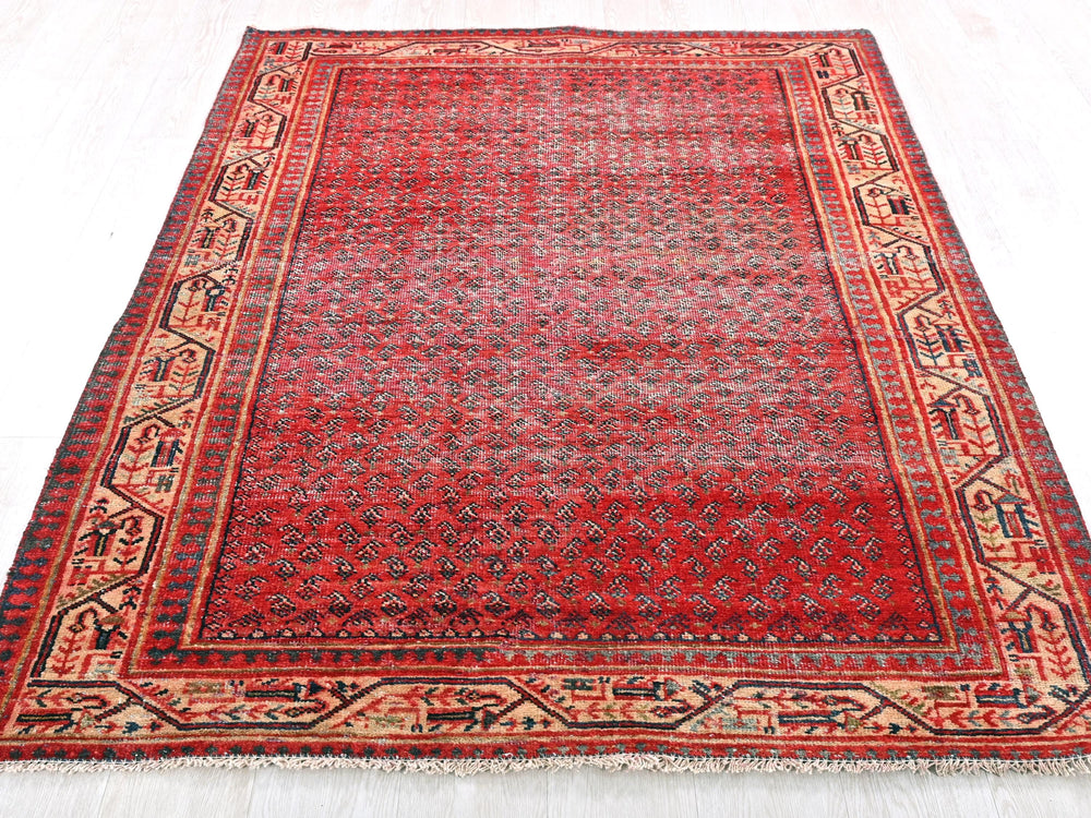 a red rug with a blue border on a white floor