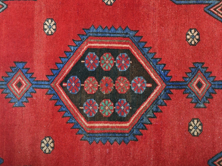 a close up of a red rug with blue and red designs