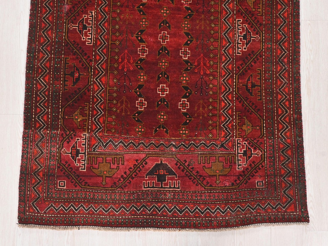 a red rug with a design on the middle of it