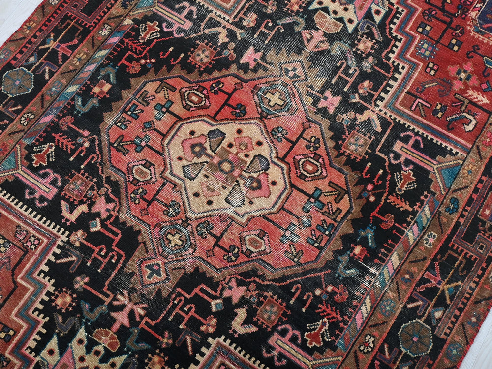 a red and black oriental rug on a white floor