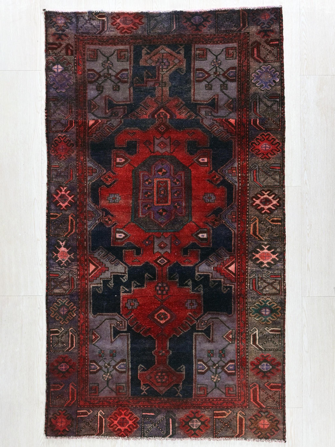 a red and black rug on a white wall