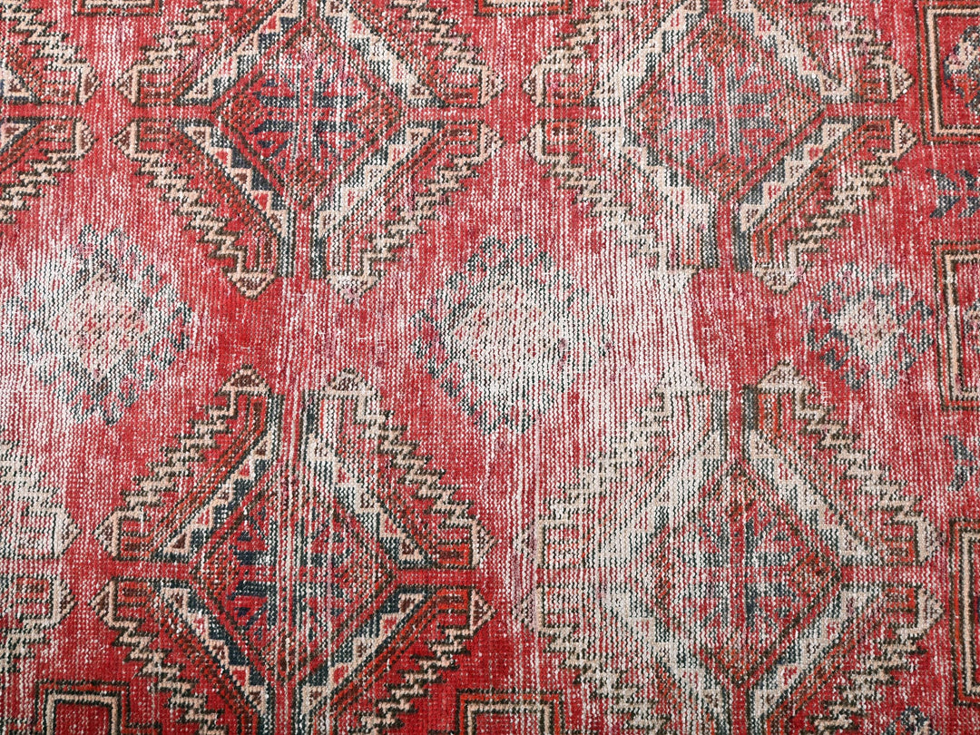 a red rug with a pattern on it