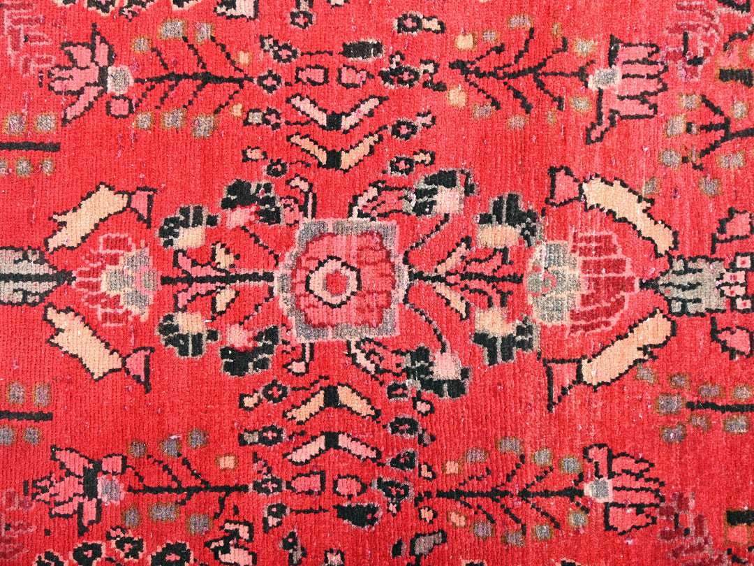 a red rug with a floral design on it