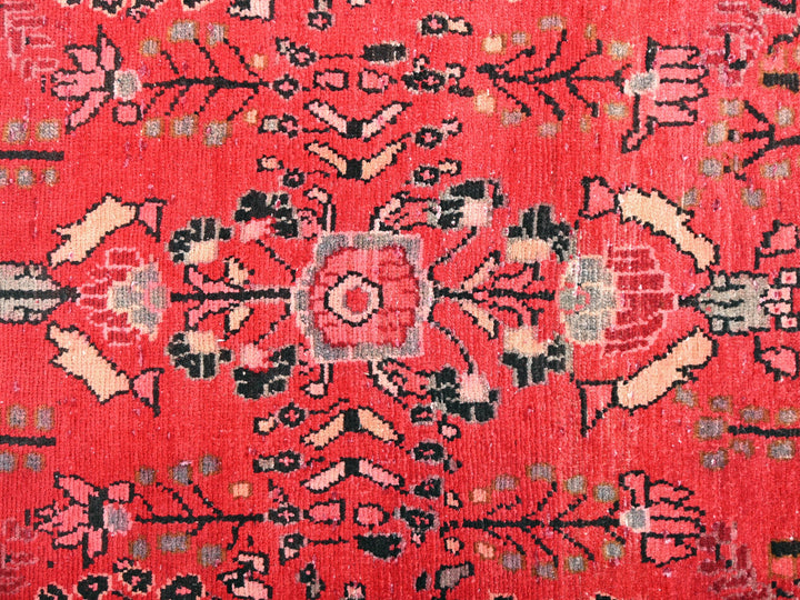 a red rug with a floral design on it