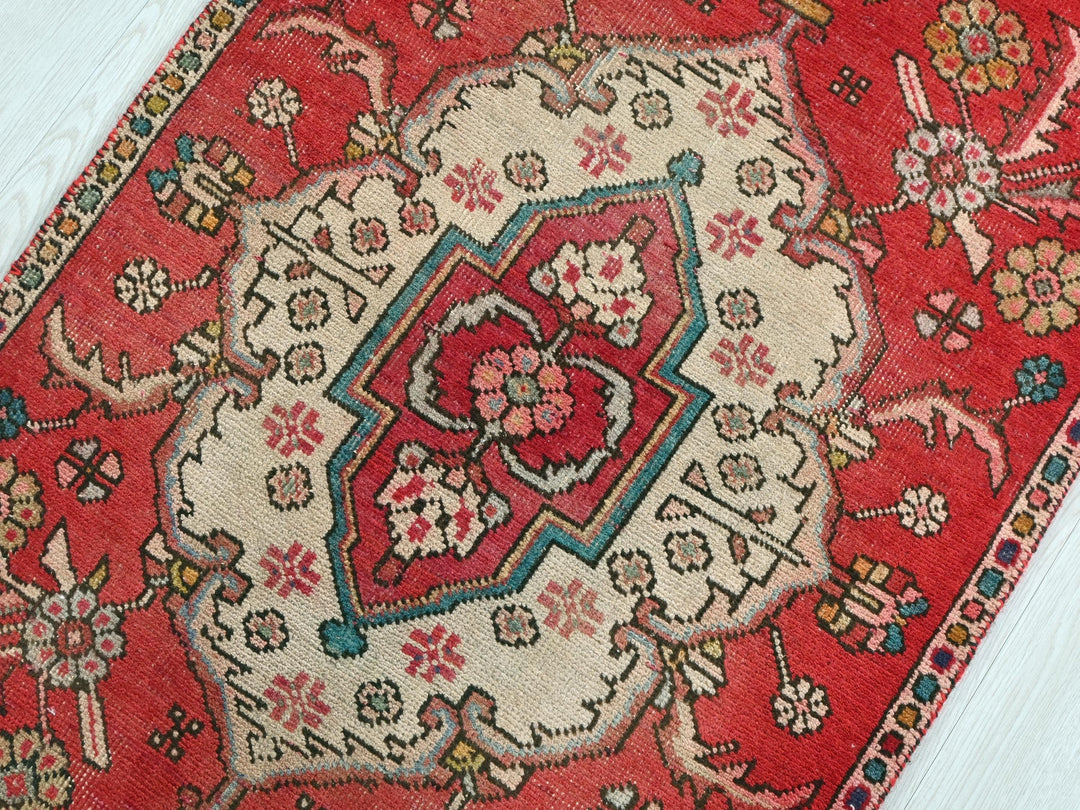 a red oriental rug on a white wooden floor