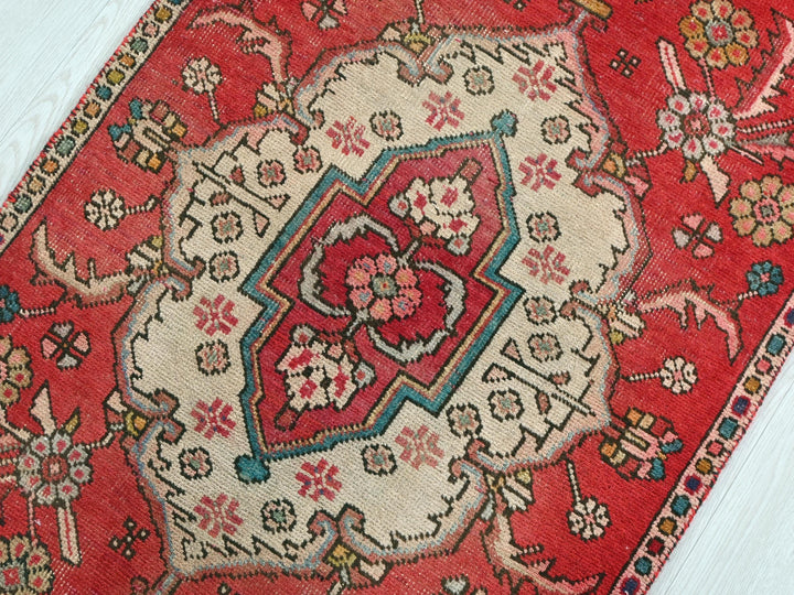 a red oriental rug on a white wooden floor
