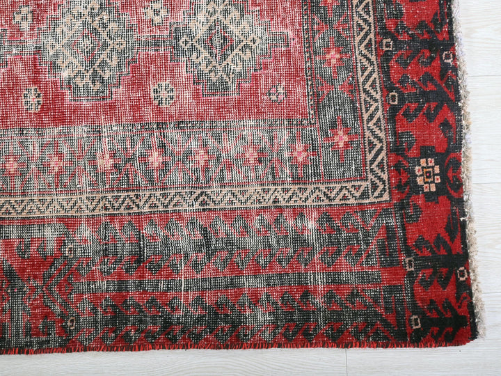 a red and black rug on a white surface