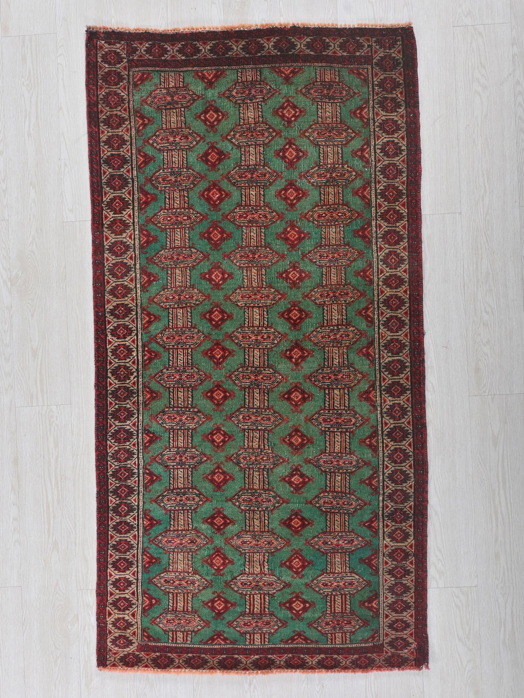 a green and red rug on a white floor