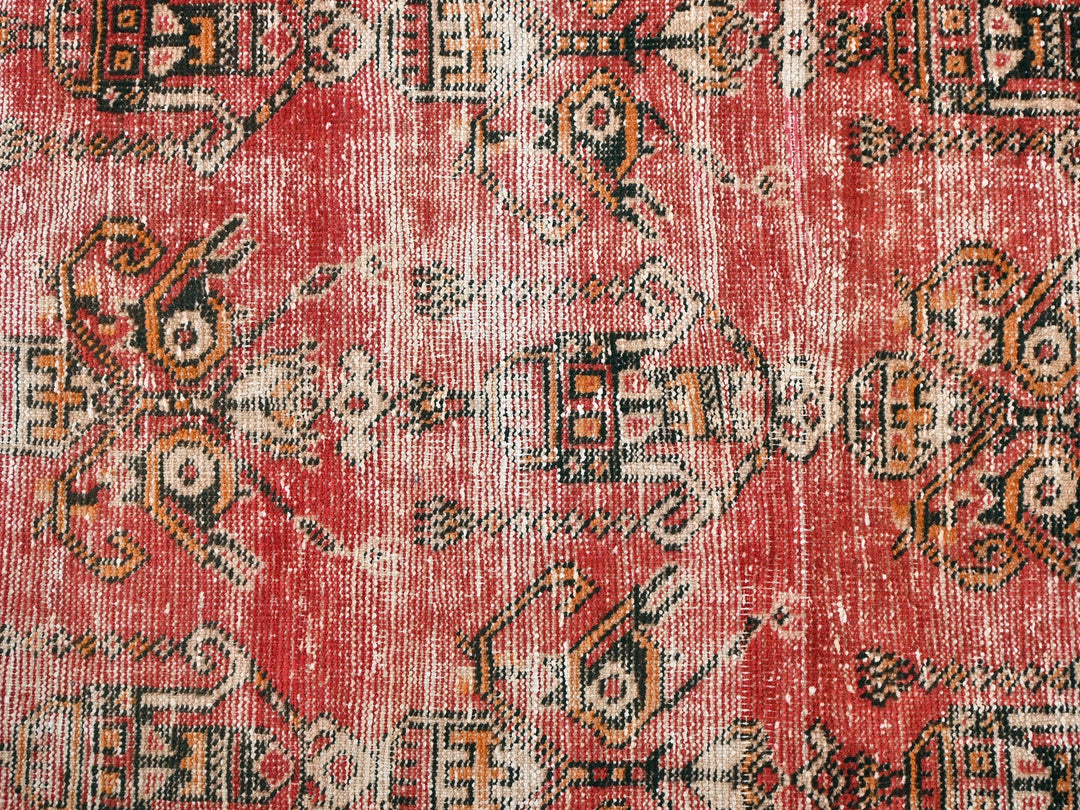 a red rug with a pattern on it