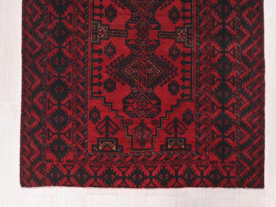 a red and black rug on a white floor