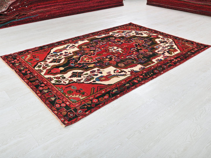 a red and black rug on a white floor