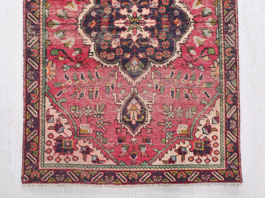 a red rug with a floral design on it