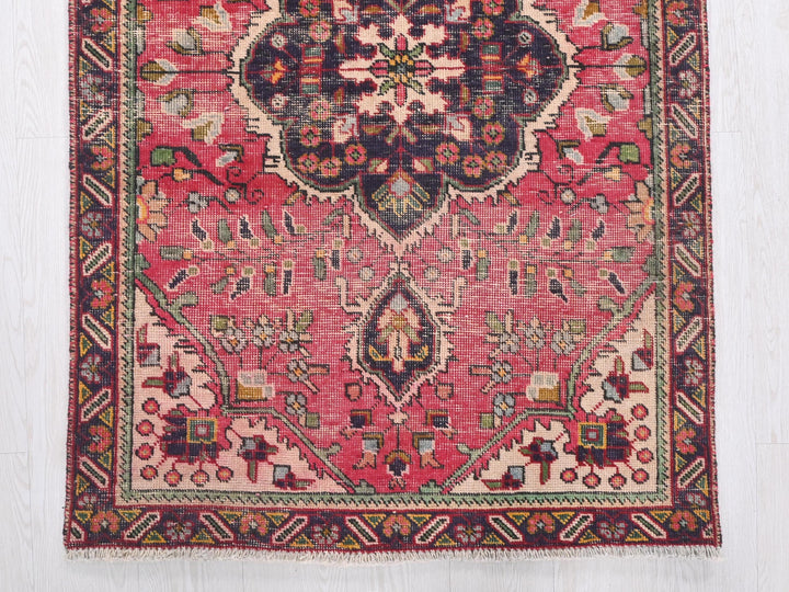 a red rug with a floral design on it