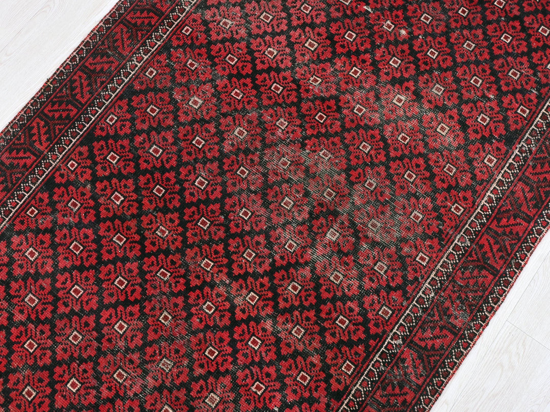 a red and black rug on a white floor