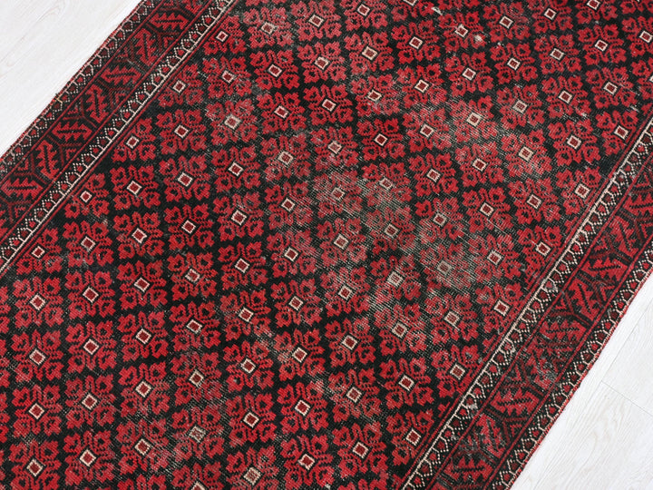 a red and black rug on a white floor