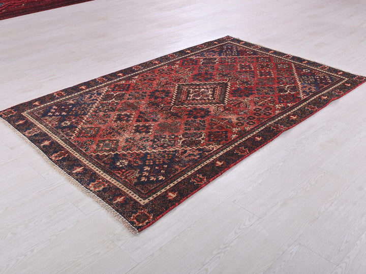 a red and blue rug on a white floor