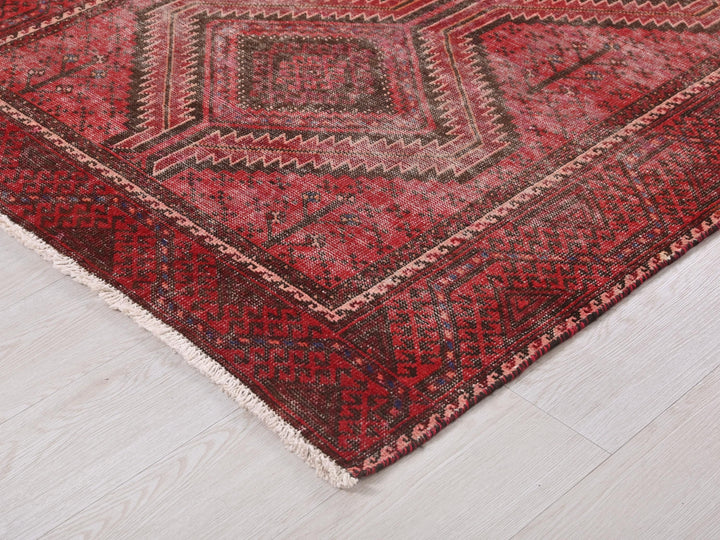 a red and black rug on a white floor