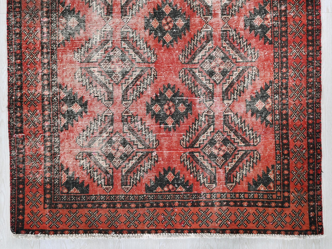 a red rug with black and white designs on it