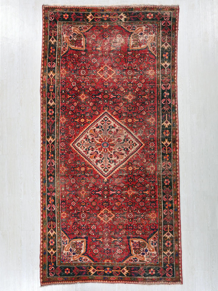 a red oriental rug hanging on a wall