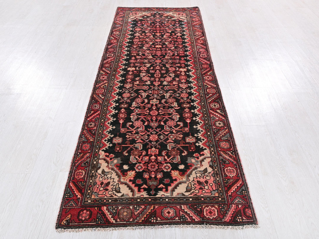 a red and black rug on a white floor